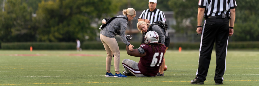 体育教练帮助受伤的足球运动员。