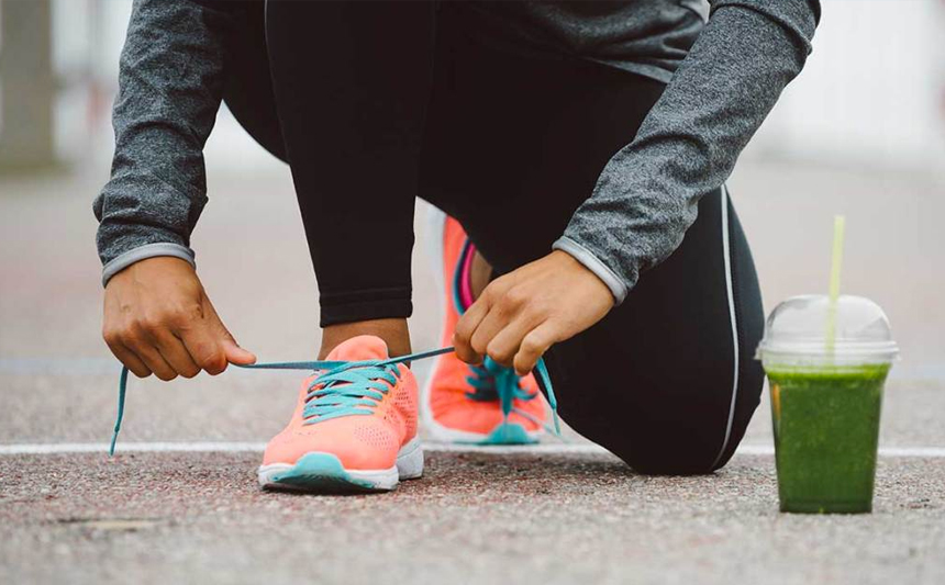 跑步者系鞋带时在人行道上休息。