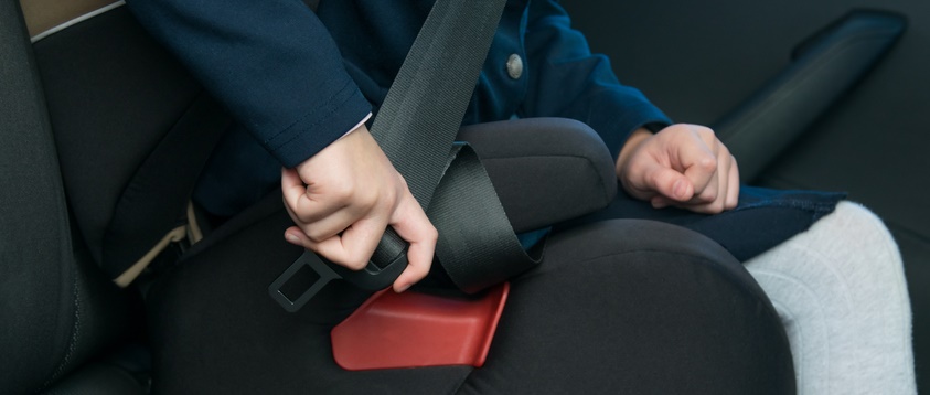 一个孩子扣上他们的汽车座椅。