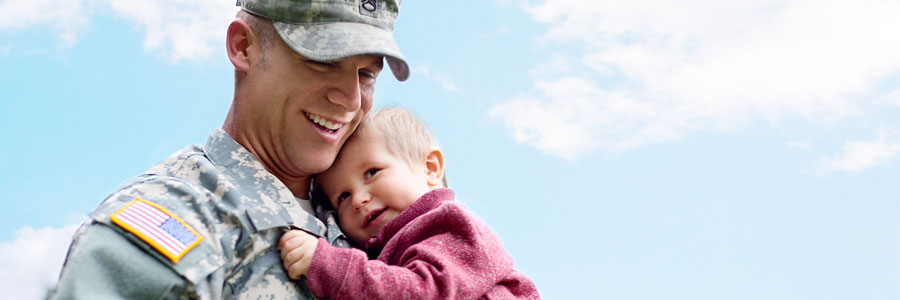 一个士兵抱着他蹒跚学步的孩子。