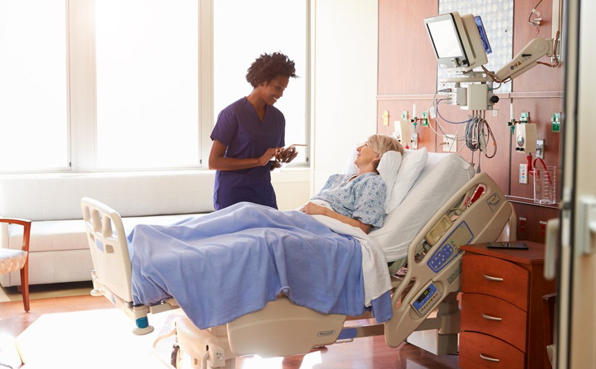 一位女护士在病房里与一位老年女病人交谈。