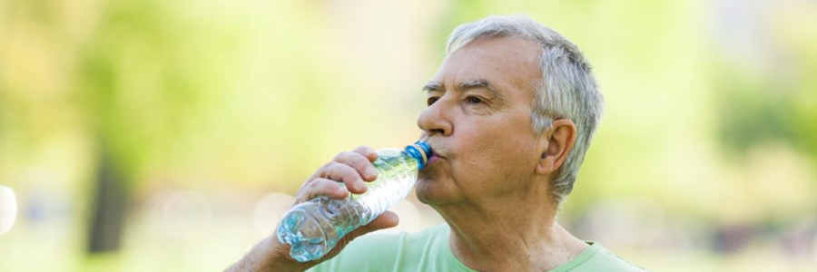 一位老人用水瓶喝水。