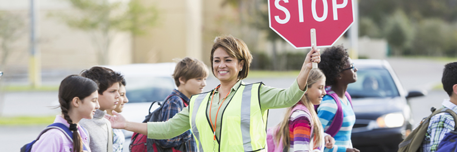 中学生过马路的协助下与停车标志协管员。