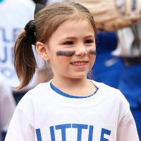 一个特写的照片在垒球场上Kailey她的脸颊上画有黑色条纹。