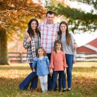 肖尼西家族的照片摆栅栏外和一个红色谷仓模糊的背景。