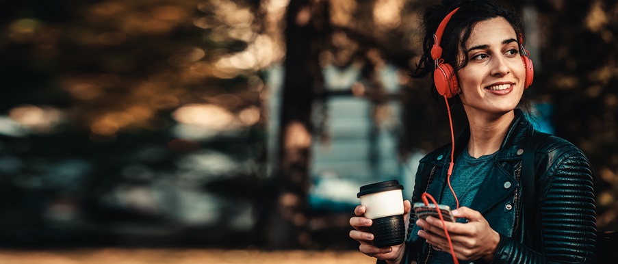 一位女士戴着红色耳机，喝着咖啡。